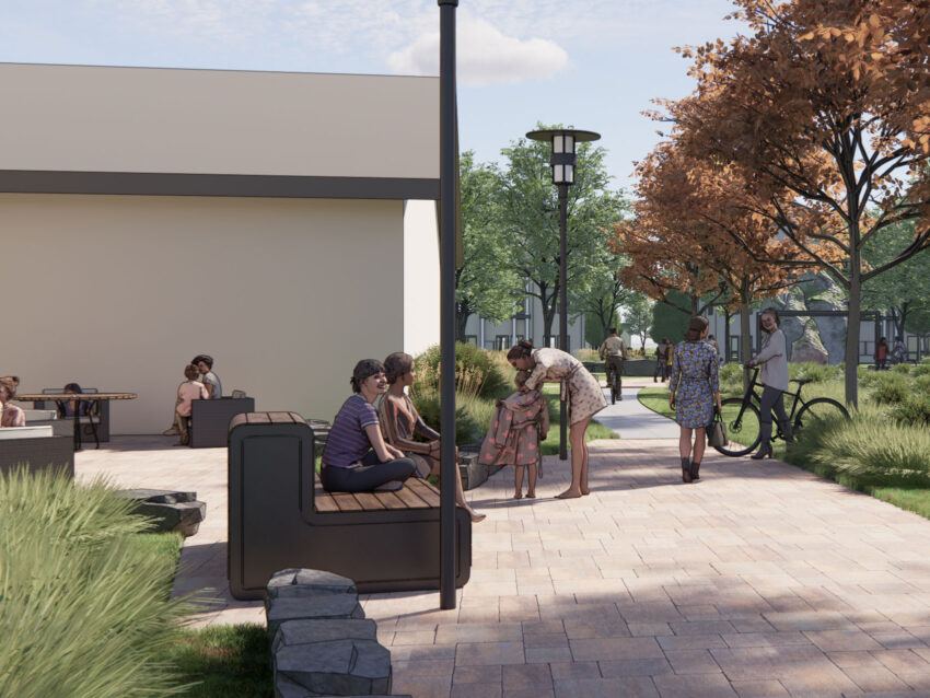 People socializing in outdoor walkway and green space. Some people are sitting at tables or on benches as neighbors greet one another